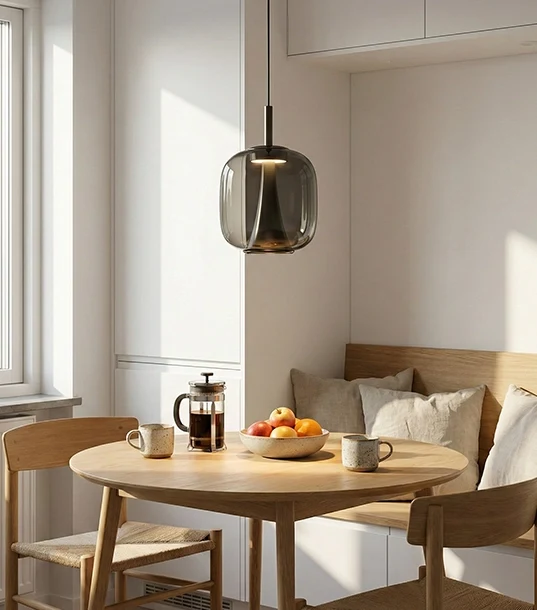 چراغ آویز مدرن ۱۲ وات مدل LC215 با حباب شیشه‌ای دودی و هسته نوری مخروطی، آویزان بالای میز ناهارخوری چوبی گرد در یک فضای روشن و مینیمال.